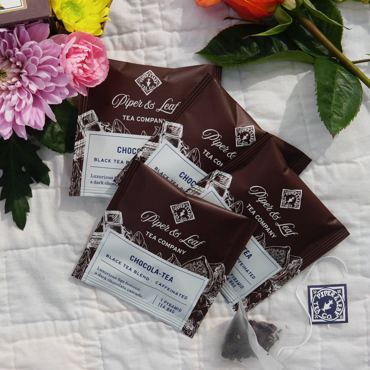 The Mother's Day Special Tea Sampler by Piper & Leaf Tea Co. features 16 individually wrapped tea bags, elegantly packaged—an ideal gift or sampler for Mother's Day, with floral accents and a brand sticker adding to its charm.