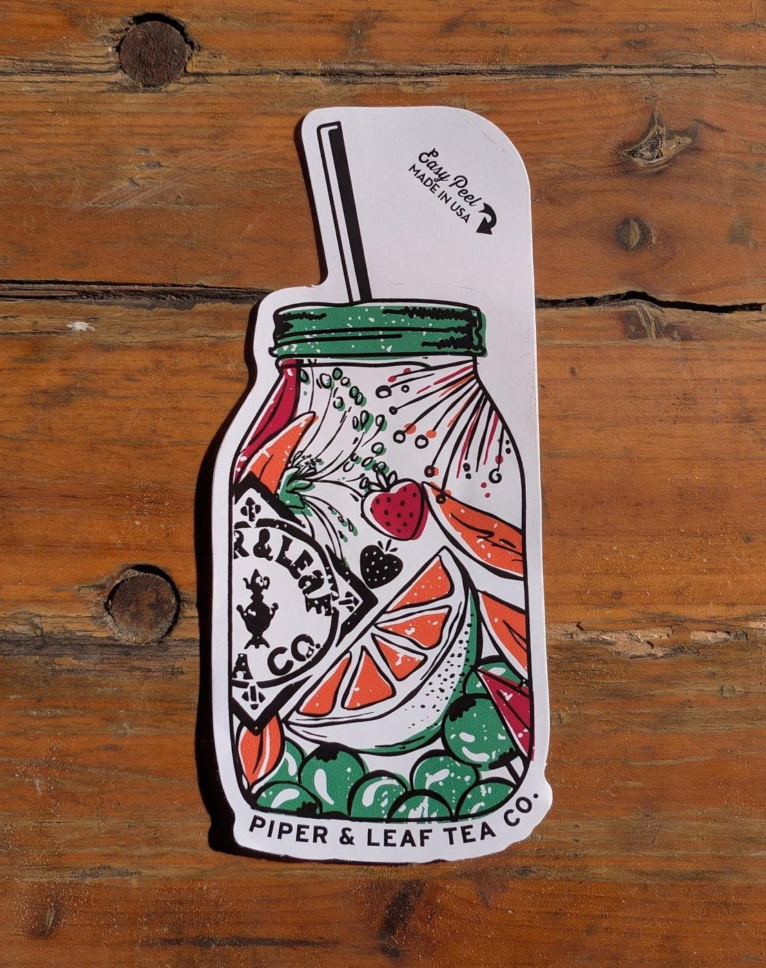 Brighten your collection with the Jar of Berries Sticker from Ninja Transfers, shaped like a mason jar with fruit, greens, and a straw on a wooden surface.