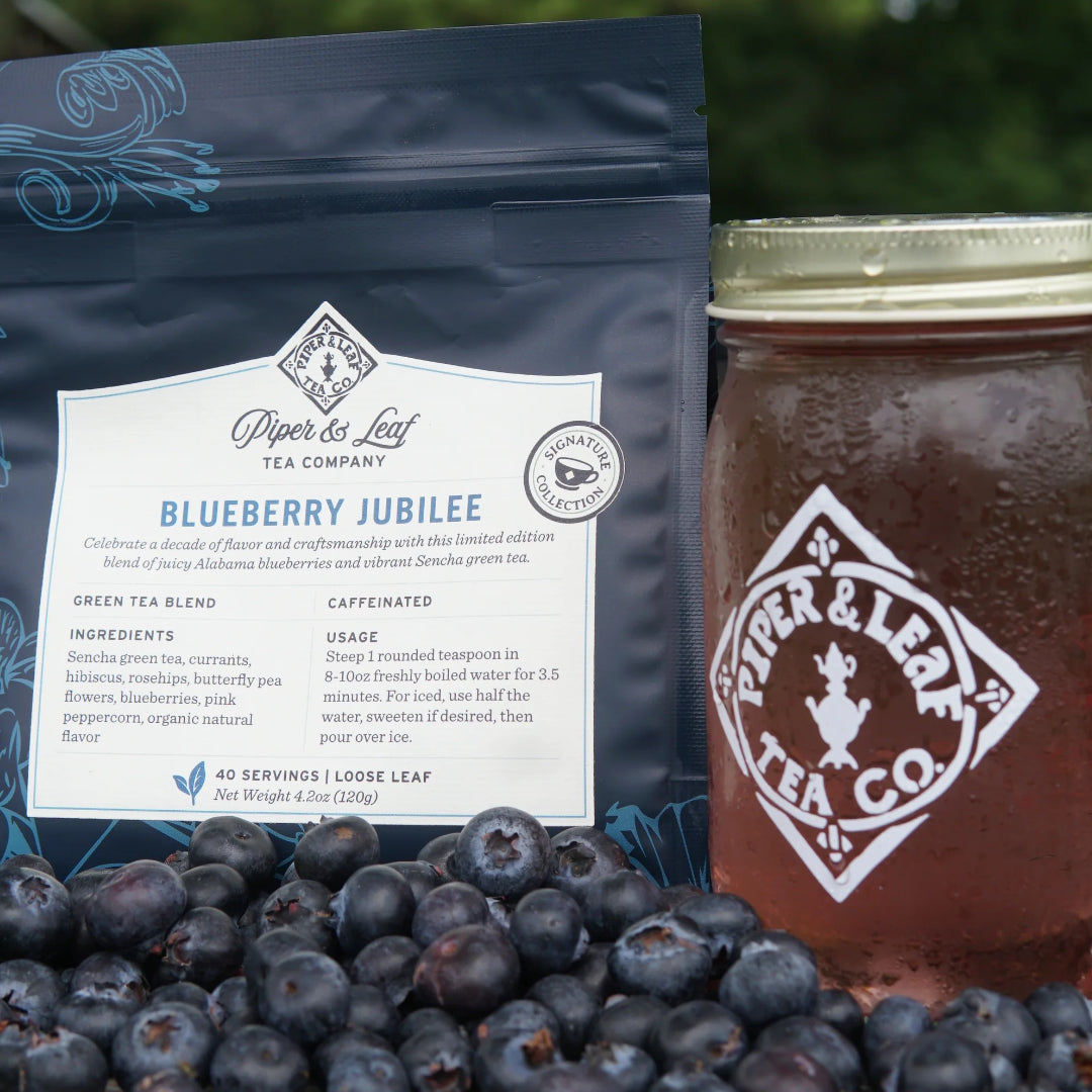 Piper & Leaf Blueberry Jubilee tea package with a jar of green tea and fresh blueberries
