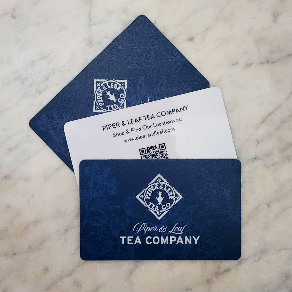A trio of blue gift cards with berries, flowers, & herbs beneath the Piper & Leaf logo. Front: "Piper & Leaf Tea Company" Back: "Shop & Find Our Locations at: www.sanbead.live"